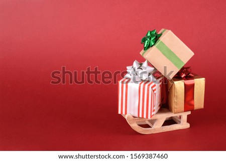 Christmas or New year background design. Winter sleigh and gift box on red background. Christmas background with space for text