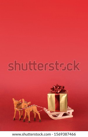 Christmas or New year background design. Reindeer with winter sleigh and gift box on red background. Christmas background with space for text