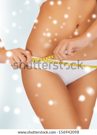 food, nutrition, sport, slimming, diet concept - woman with measure tape