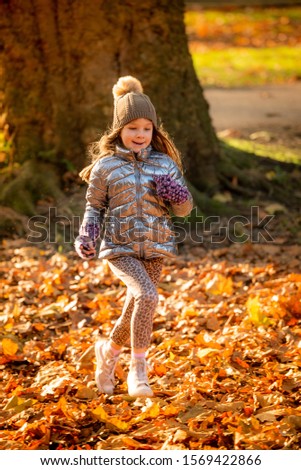 Beautiful Young Girl having fun in the park in autumn
