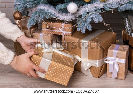 male hands lay Christmas gift under Christmas tree winter holidays happy time concept wallpaper pattern photography 