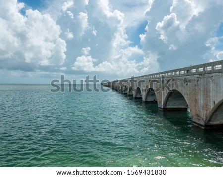Old seven mile bridge shot on little Duck key, Florida with clouds and sea on a sunny day. Bridge going on forever, symbol of eternity.
