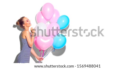 Beauty Valentine's Day girl with colorful air balloons laughing over white background. Beautiful Happy Young woman on birthday holiday party. Joyful model having fun, love, celebrating. Balloon