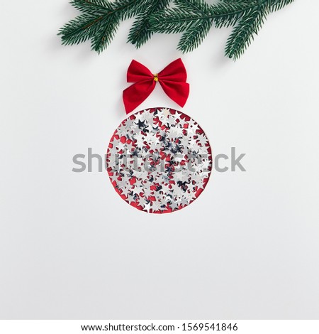 Christmas minimal concept - abstract christmas bauble made of silver confetti star and red bow. Christmas greeting card. Xmas concept. Xmas ball. Abstract christmas card.