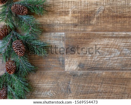 Pine swag with pine cones  on rustic wood background, for Christmas. Great for adverts, flyers,greeting cards, web design, etc. Can be used vertical or horizontal,flip left/right.