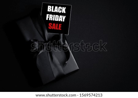 Top view of Black Friday Sale text with black gift box isolated on black background. Shopping concept boxing day and black Friday composition.