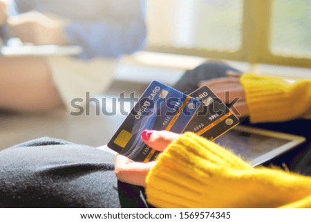 Online shopping, Communication, Technology and Business Concept - Woman hands holding two credit card with Tablet sitting on floor and sunlight flare. Copy space and Selective focus