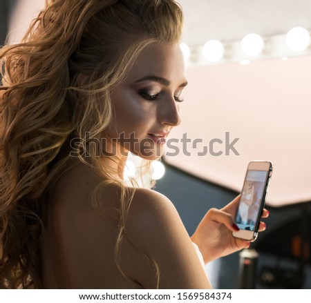 Young bride with nice hair style holding her phone