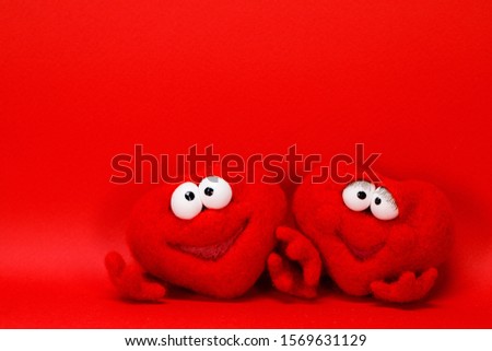 Two wool red hearts on red background with copy space for text, symbol of love, healtcare, valentines day concept