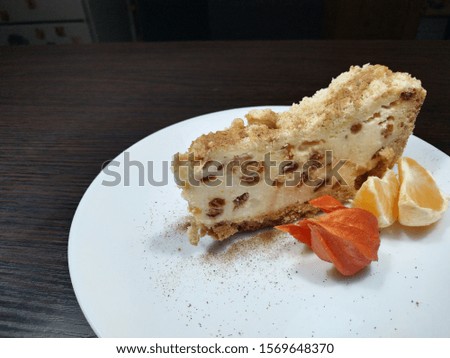 
Piece of cheese pie on a plate with slices of tangerine