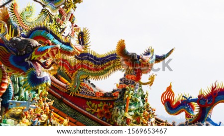 bright multi-colored sculptures of Japanese samurai dragons on the roof of traditional temples. religion in asia. a religious temple rises above a Chinese city. korean chinese japanese temples