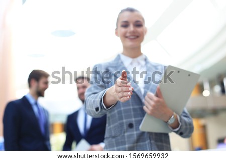 woman with an open hand ready for handshake in office.