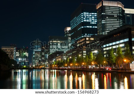The city lights of Tokyo reflect off of the water.