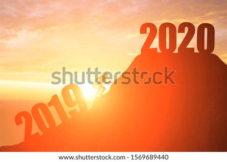 silhouette of business man go to 2020 from 2019 on the mountain