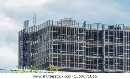 Building under construction, scaffolding and other construction elements. Royalty-Free Stock Photo #1569691066