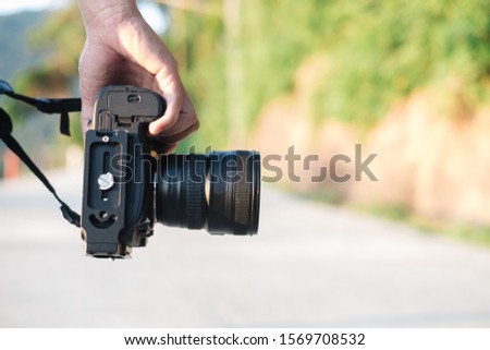Close up, Young man asian photographer holding digital camera DSLR