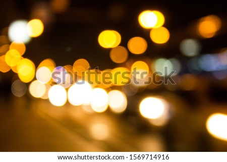 Bright blurred night city lights along the road. Abstract flickering lights with bokeh effect background.