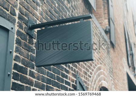 Empty black outdoor banner on brick wall. Commercial and ad concept. Mock up
