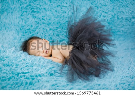 Lovely fashion Newborn baby wearing tutu skirt on carpets background.