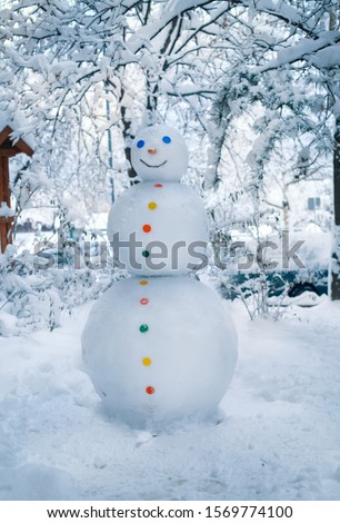 Funny snowman in without  hat on snowy field. Snowman wish you merry Christmas. Handmade snowman in the snow outdoor. Snowman and snow day
