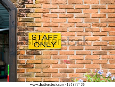 staff only sign on brick wall.