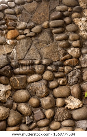 Stone wall of cobblestones covered with varnish