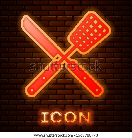 Glowing neon Crossed knife and spatula icon isolated on brick wall background. BBQ knife and spatula sign. Barbecue and grill tools.  Vector Illustration