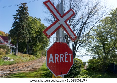 Red and white train crossing stop sign written in french. Quebec. Canada