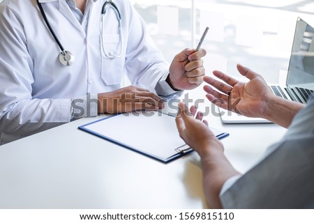 Doctor and patient are discussing consultation about symptom problem diagnosis of disease talk to the patient about medication and treatment method. Royalty-Free Stock Photo #1569815110