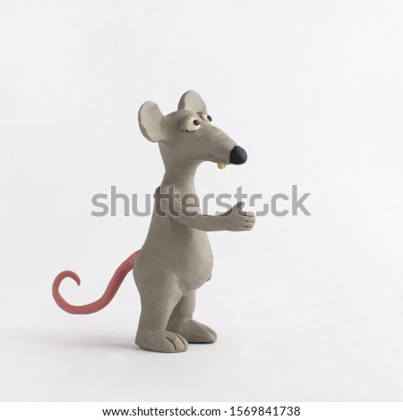 The mouse stands sideways and holds out his hand in greeting. Plasticine character Royalty-Free Stock Photo #1569841738