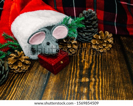 Happy New Year! Symbol of the New Year 2020 - White or Silver Rat Metallic Cute artificial Rat peeps from the cap of Santa Claus on a wooden surface Decorated with Christmas.