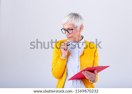 Mature Businesswoman in formal wear thinking about Job offer before signing documents. business woman holding clipboard. Modern, hardworking woman holding clip board in hands