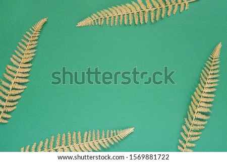 Festive green background with gold decoration , holiday background with glitter shiny golden fern leaves , flat lay, top view, copy space