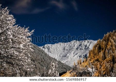 Winter night landscape on a background of mountains and a silent star in the town of Neustift in the Stubai Valley in Austria.