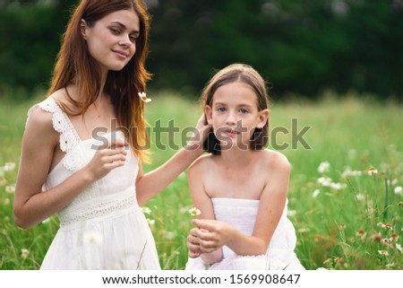 Mom and daughter in white dresses nature leisure fun