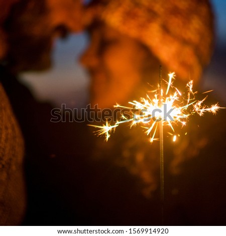 Romantic couple concept celebrating new year eve holiday christmas together with love - closeup of sparklers and people in background in celebration picture