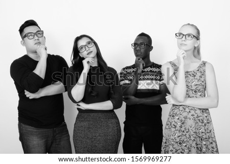 Studio shot of diverse group of multi ethnic friends thinking while looking up with eyeglasses together