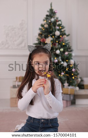 Christmas portrait of a beautiful girl with long blond hair in a playful mood depicts different emotions