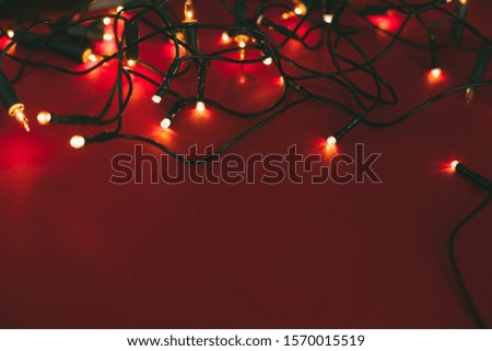 Golden Christmas garland on red background. Place for text.