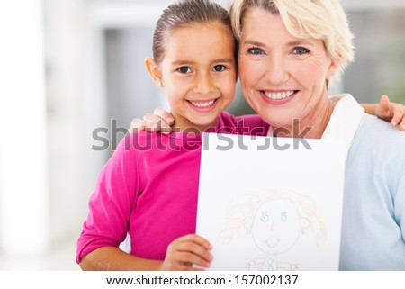 cute little girl showing a drawing of her grandma 