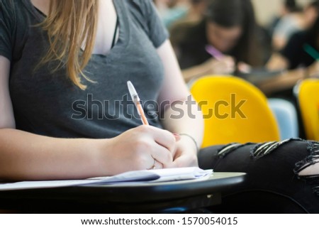 Young student writing with a pen during an educational test