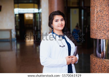 Portrait of a doctor intern. Female medical student smiling at camera in university