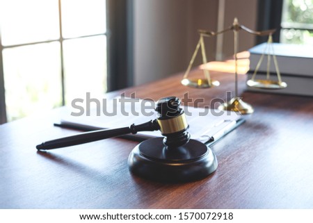 Judge gavel with Justice at law firm in background with legal case document contract, law and justice, attorney, lawsuit.