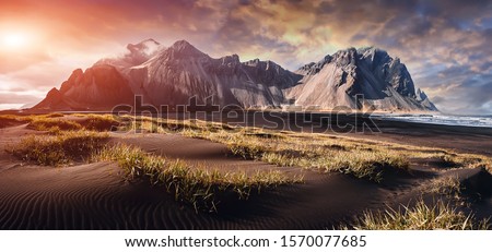 Impressive view of Vestrahorn mountaine on Stokksnes cape in Iceland during sunset. Amazing Iceland nature seascape. popular tourist attraction. Best famouse travel locations. Scenic Image of Iceland Royalty-Free Stock Photo #1570077685