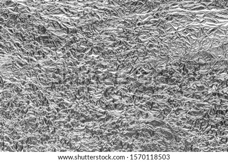 Texture of crumpled aluminum kitchen foil. Black and white abstract blank for design.
