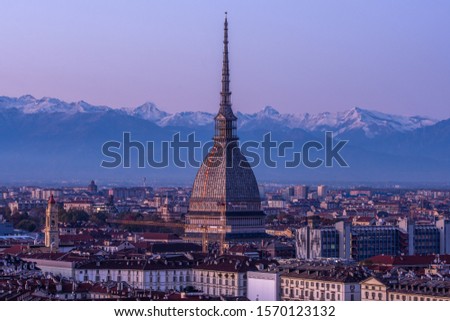 La Mole Antonelliana at sunset with mountains in backgrounds. Turin, Piedmont, Italy.