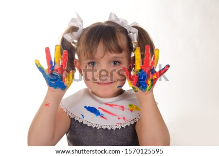 Little girl with hands covered in finger paint after painting a picture