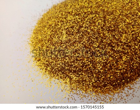 mound of gold color powder on a white background