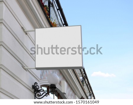 Blank white square sign on wall mock up, sky background. Empty coffeeshop or confectionery display wal mounted mockup. Clear flowershop signpost for advert mokcup template.