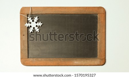 White snowflake on the old black blank chalkboard isolated on the white background